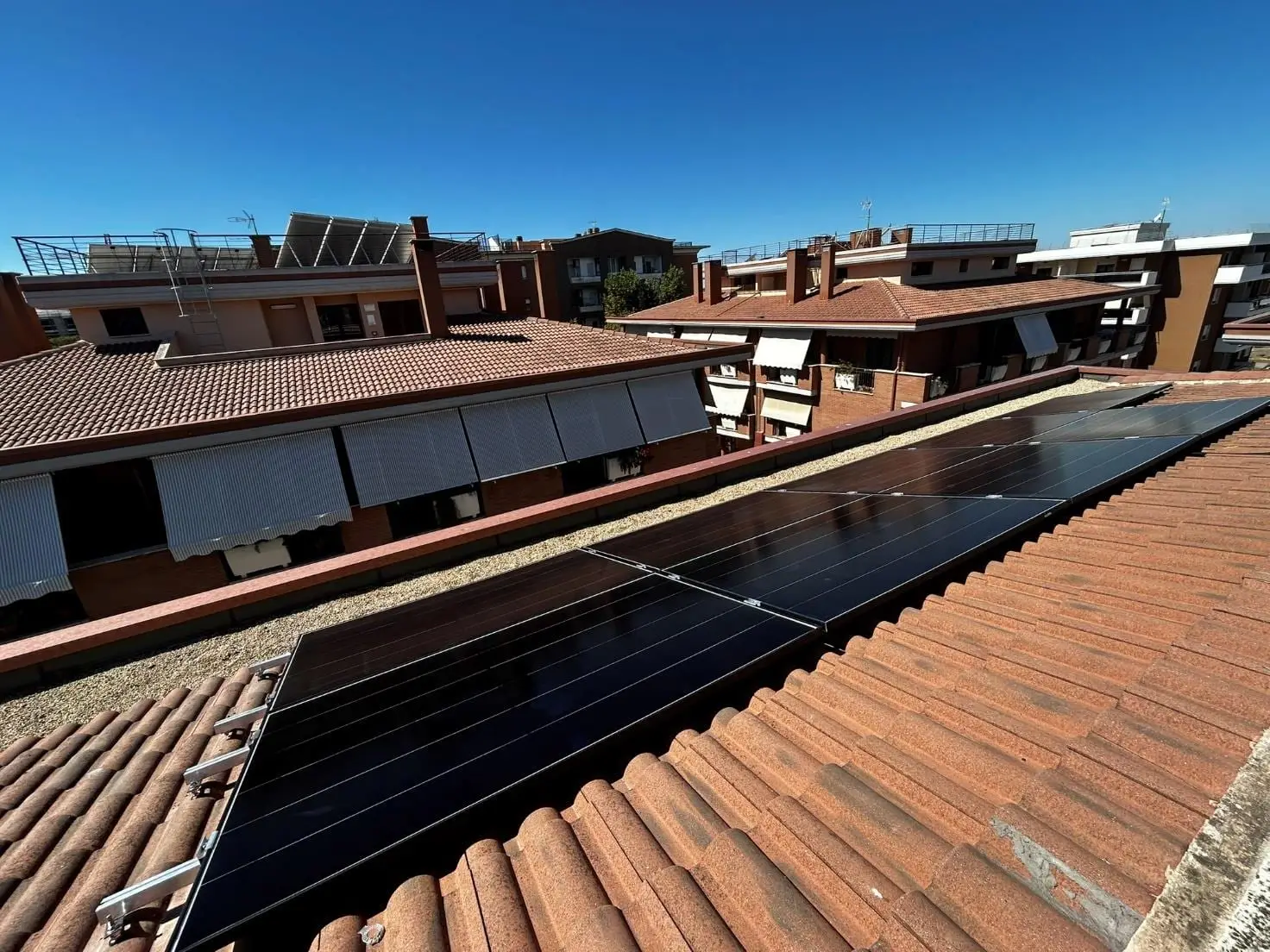 Impianto fotovoltaico su un tetto a falda tra le palazzine