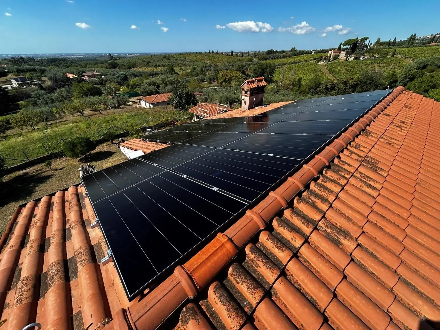 Impianto fotovoltaico su un tetto in coppi con vista sulla campagna